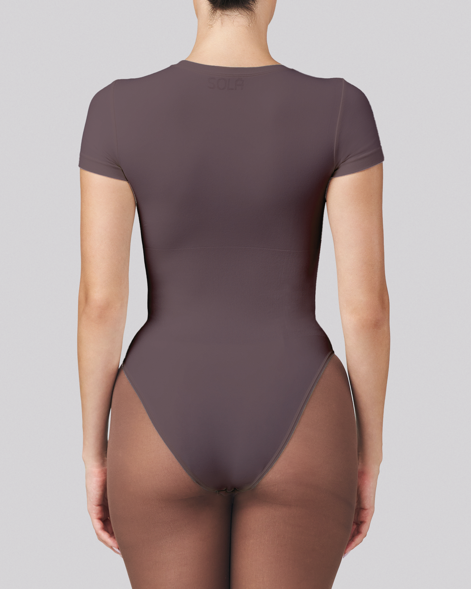 Brown bodysuit worn by a model on a gray background
